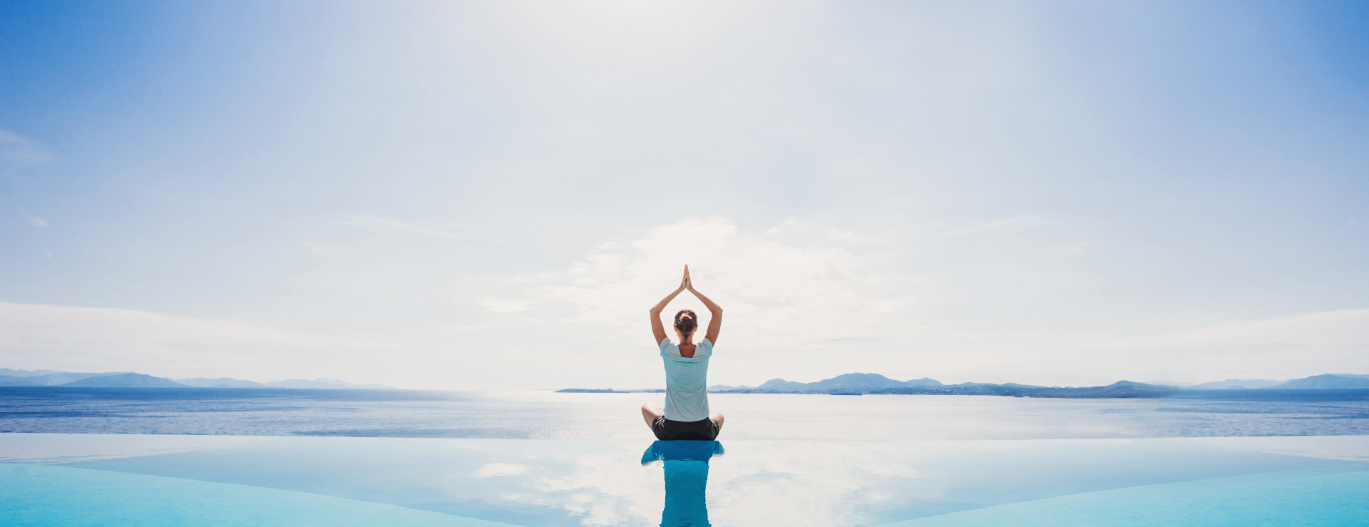 Frau macht Yoga im Meer