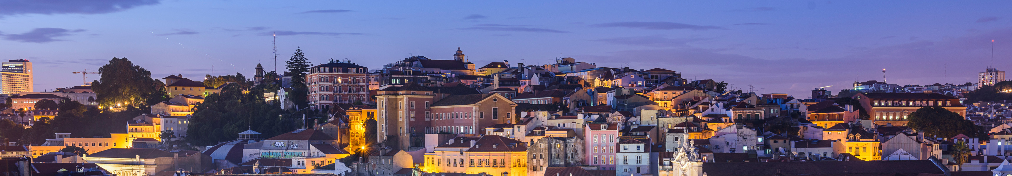 Beleuchteter Rossio-Platz mit Nationaltheater und historischer Altstadt in Lissabon bei Abendstimmung