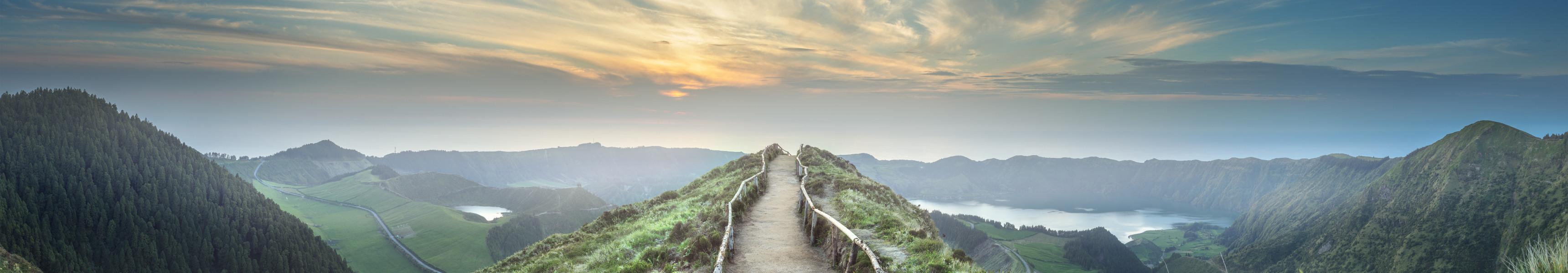 Panoramablick vom Aussichtspunkt Miradouro da Boca do Inferno auf die grünen Berge und die Seen von Sete Cidades auf der Insel São Miguel, Azoren, Portugal, bei Sonnenuntergang.