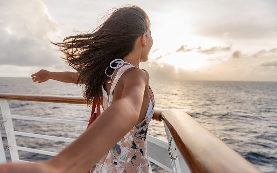 Frau an Deck eines Kreuzfahrtschiffes