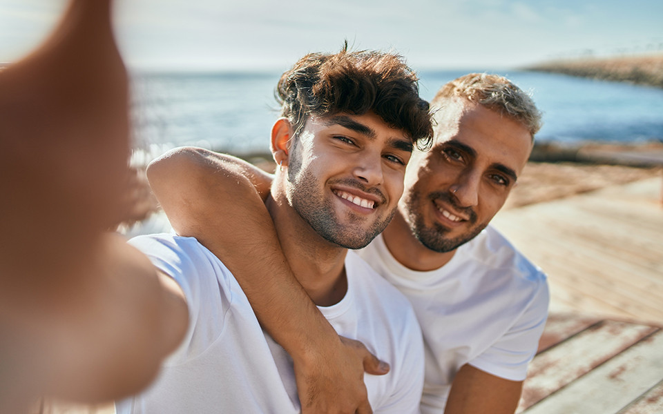Zwei Männer machen ein Selfie am Meer auf Mykonos