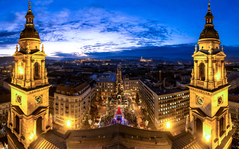 Weihnachtsmarkt in Budapest vor der St.-Stephans-Basilika, mit funkelnden Lichtern, festlicher Stimmung und einem beeindruckenden Blick &uuml;ber die Stadt in der Abendd&auml;mmerung.