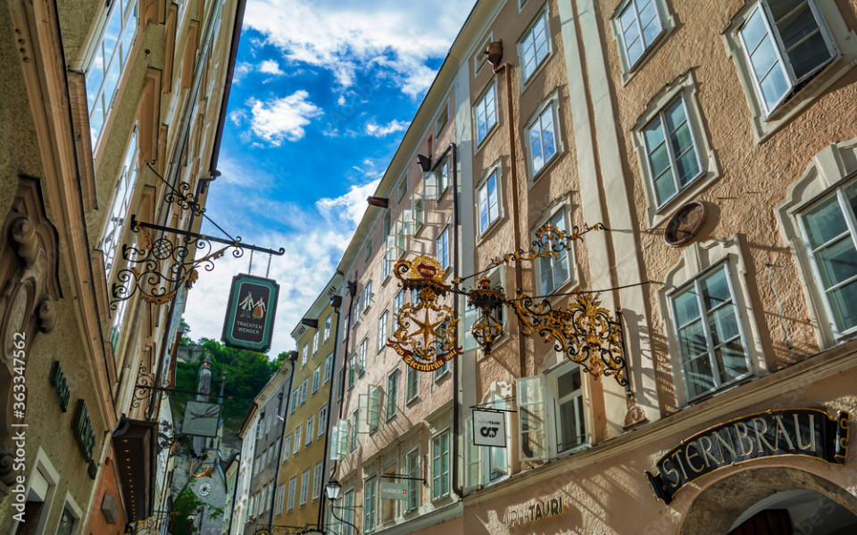 Getreidegasse in der Altstadt von Salzburg mit historischen Schildern und Hausfassaden.