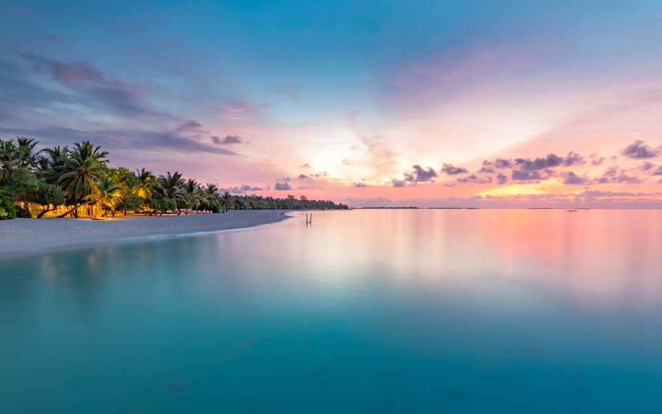 Nahaufnahme des Meeresstrandes und des farbenfrohen Sonnenuntergangshimmels in der Karibik