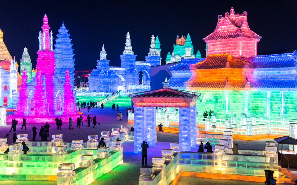 Panoramablick auf die riesigen, beleuchteten Eisskulpturen des Harbin International Ice Festival in China.